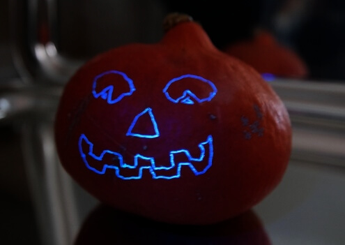 Halloween einmal feuerfest: fluoreszierendes Kürbis-Gesicht - nur unter UV-Licht sichtbar!