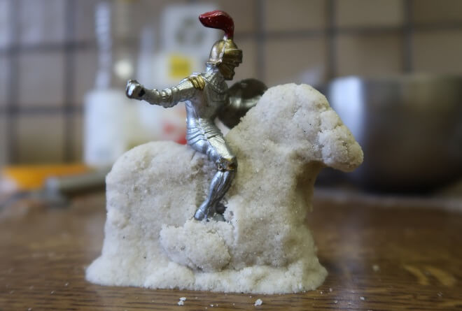 Ein Pferd aus kinetischem Sand trägt den Spielzeug-Ritter