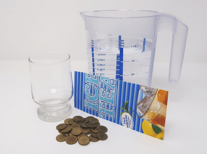 Für das Experiment braucht ihr: Trinkglas, Wasser, Pappstreifen aus Tetrapak, kleine Münzen